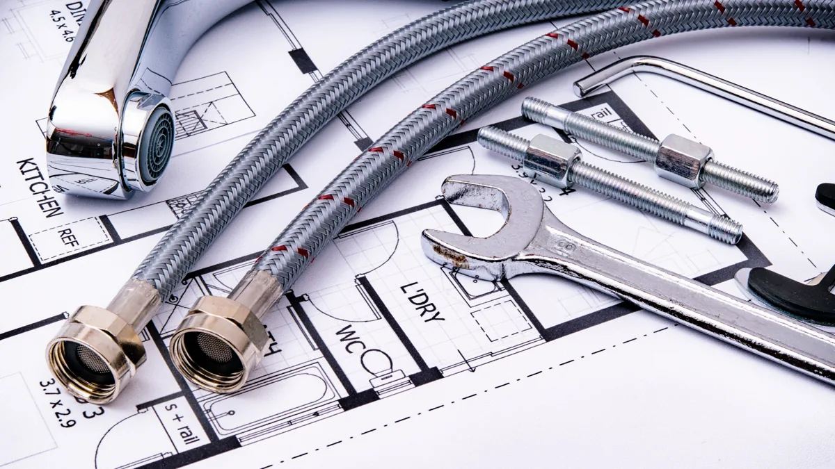 Plumbing hoses, faucet parts, and tools arranged on building plans