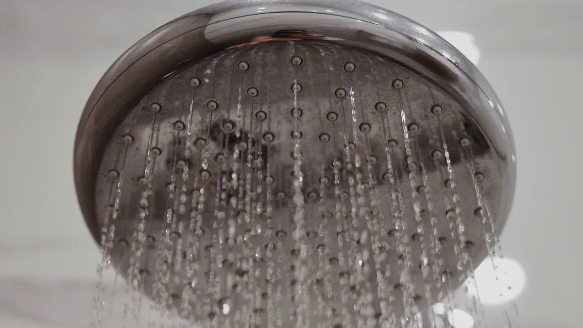 Water flowing from a round chrome shower head