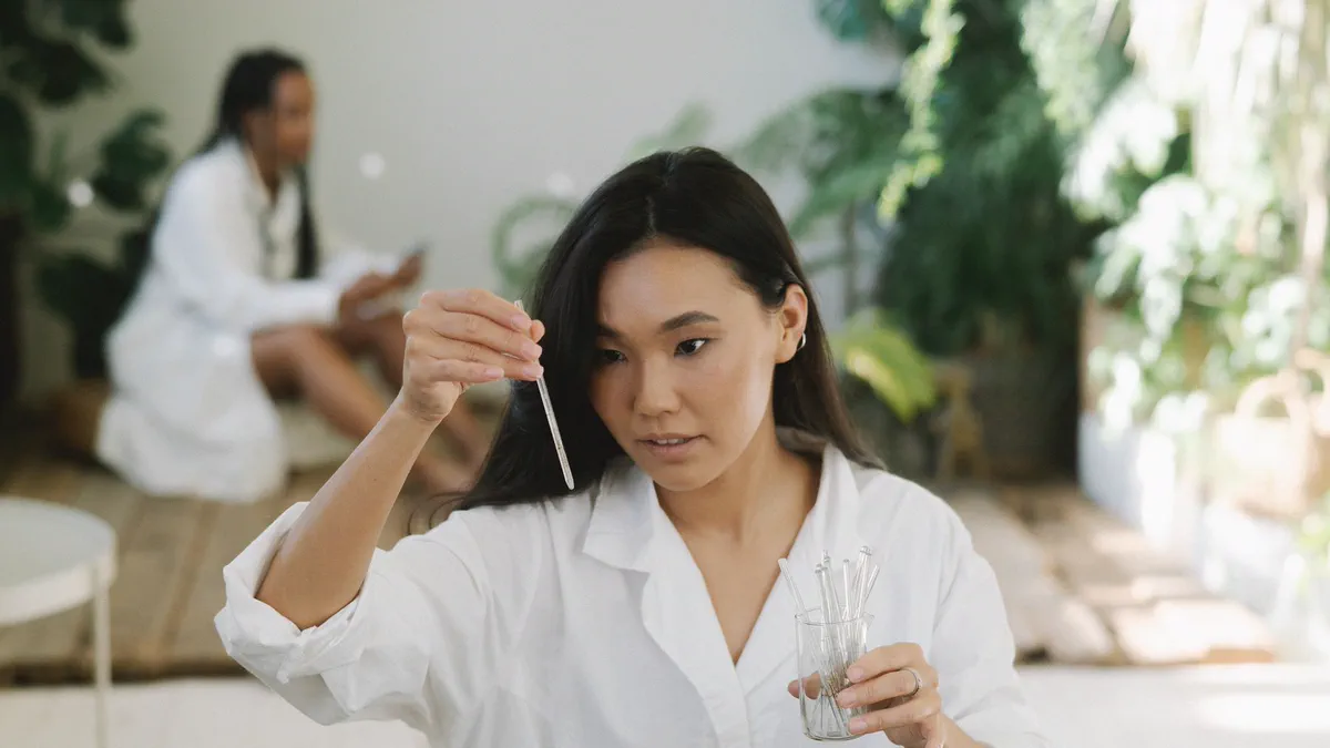Scientist examining a liquid sample with a glass pipette